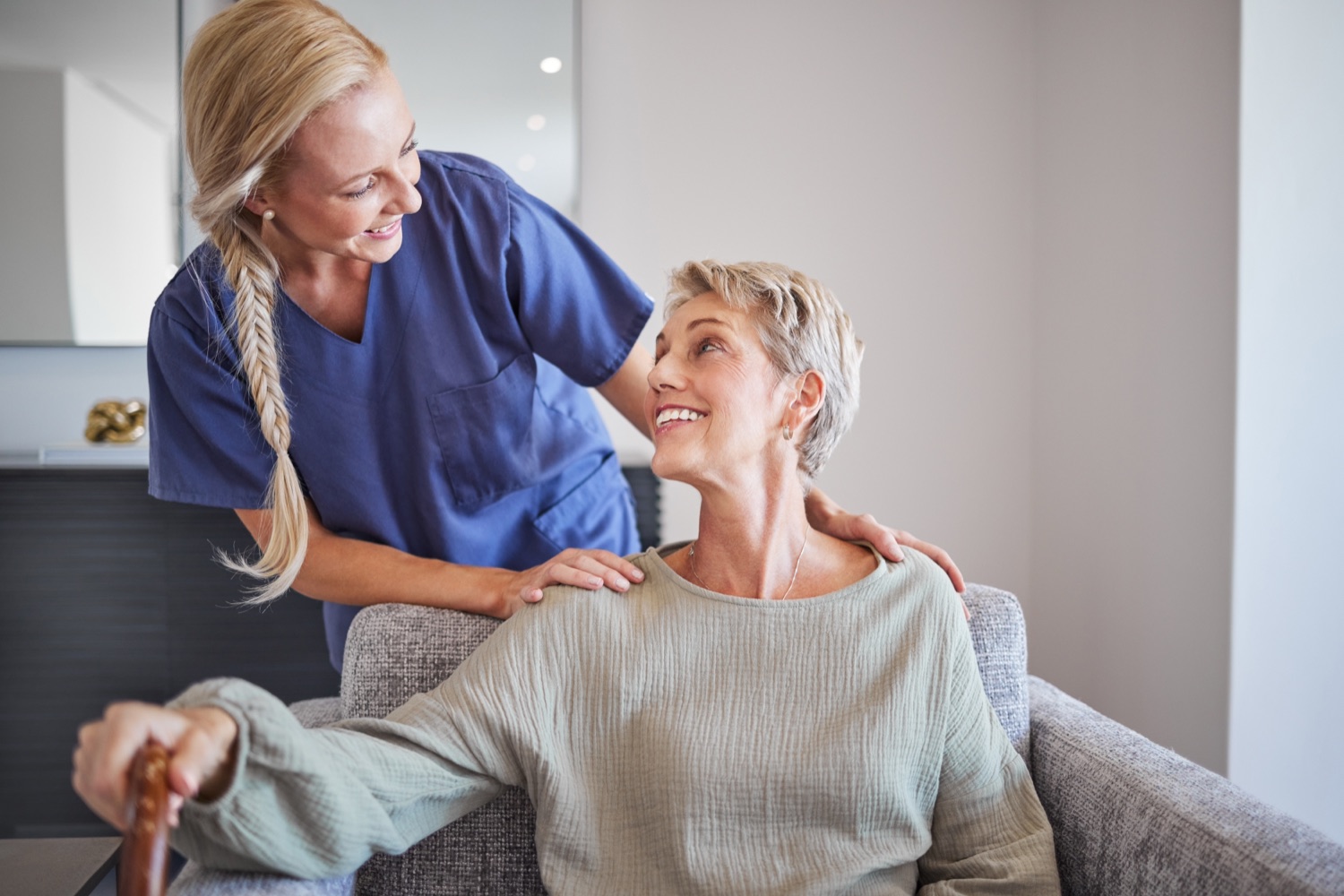A caregiver sitting with a senior woman at home during a care visit