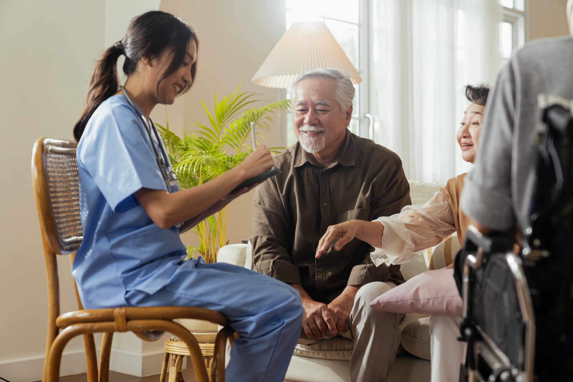 A caregiver with a senior couple in a living room